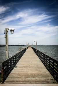 Pier on sea against cloudy sky