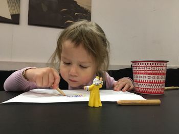 Portrait of girl holding ice cream on table