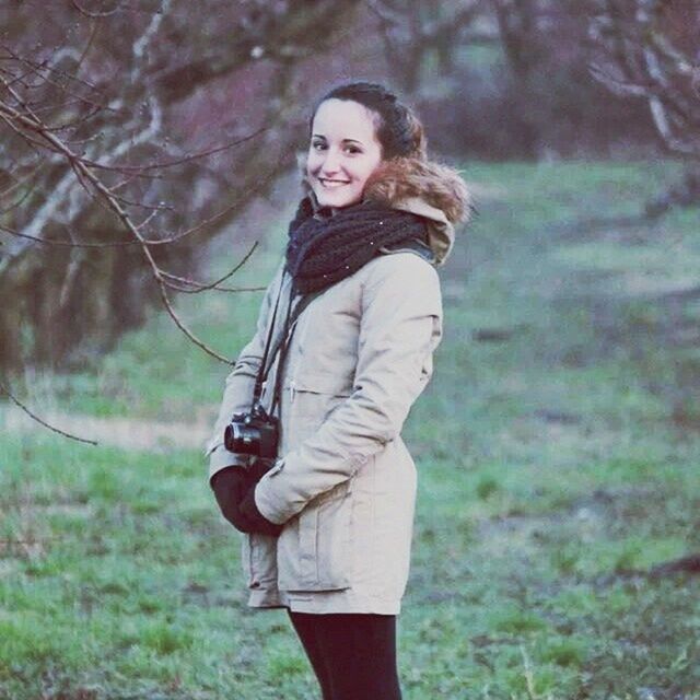 young adult, lifestyles, casual clothing, focus on foreground, person, standing, three quarter length, leisure activity, front view, tree, young women, portrait, looking at camera, full length, holding, smiling, field