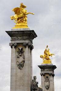 Low angle view of statue against cloudy sky