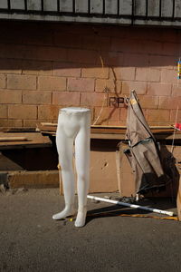 Close-up of mannequin against brick wall