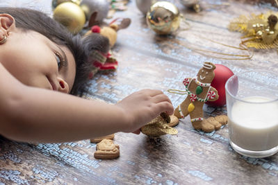 Close-up of girl playing with toy while lying down on wooden flooring