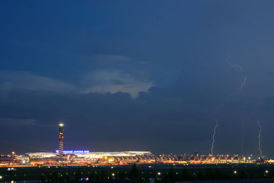 Illuminated city against sky at night