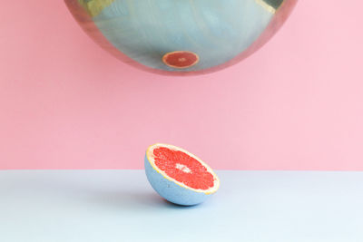 Close-up of citrus grapefruit slice reflecting on mirror