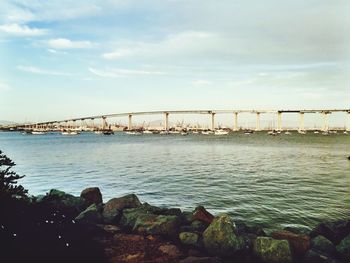 Bridge over river in city against sky