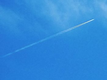 Low angle view of vapor trail against blue sky