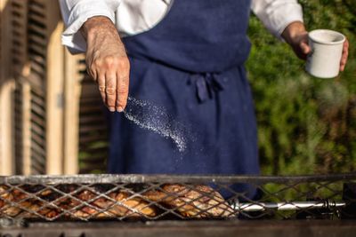 Midsection of man preparing food in yard