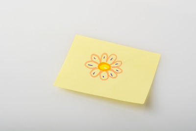 Close-up of yellow paper over white background