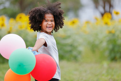 Portrait of smiling girl holding balloons