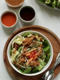 High  angle view of indonesian spicy salad, topped with peanut sauce on the table.