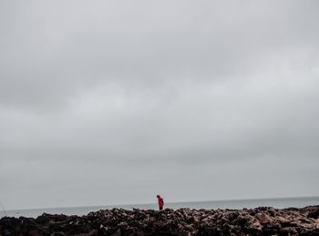 Rear view of woman looking at sea against sky