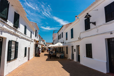 Street amidst buildings against blue sky