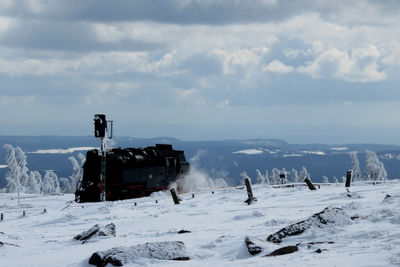 Scenic view of snow covered field against sky