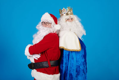 Low angle view of santa claus against blue background