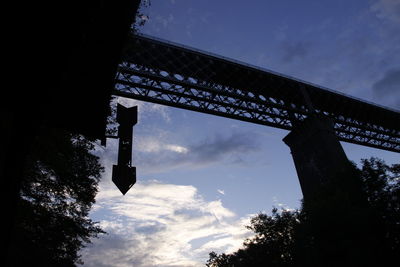 Low angle view of silhouette bridge against sky