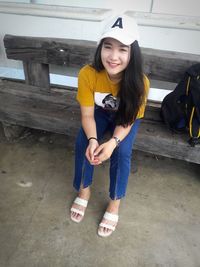 Portrait of smiling young woman sitting outdoors