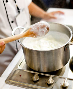 Close-up of hand holding ice cream in kitchen