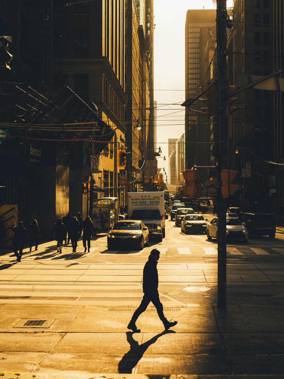 SILHOUETTE PEOPLE WALKING ON STREET AMIDST BUILDINGS