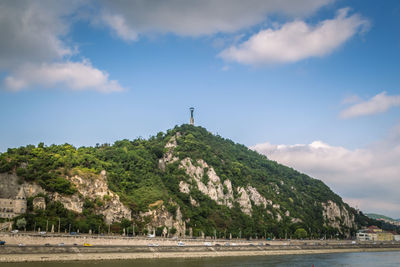 Scenic view of sea by mountains against sky