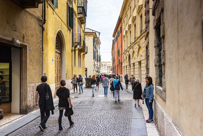 People walking on street amidst buildings in city