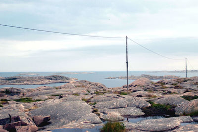 Rocks by sea against sky