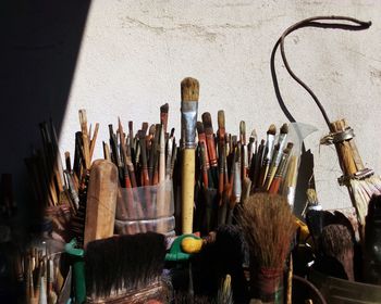 Close-up of paintbrushes on table against wall