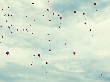 Low angle view of balloons flying against sky