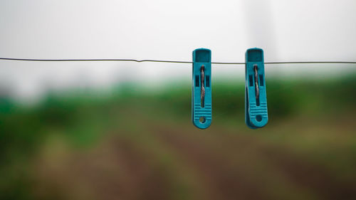Close-up of clothespins on rope against blurred background