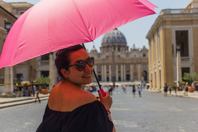 Woman holding umbrella in city