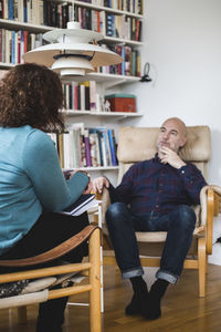 Female therapist talking with male patient at home office