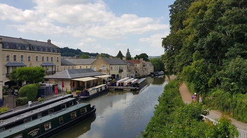 Canal amidst buildings in city against sky