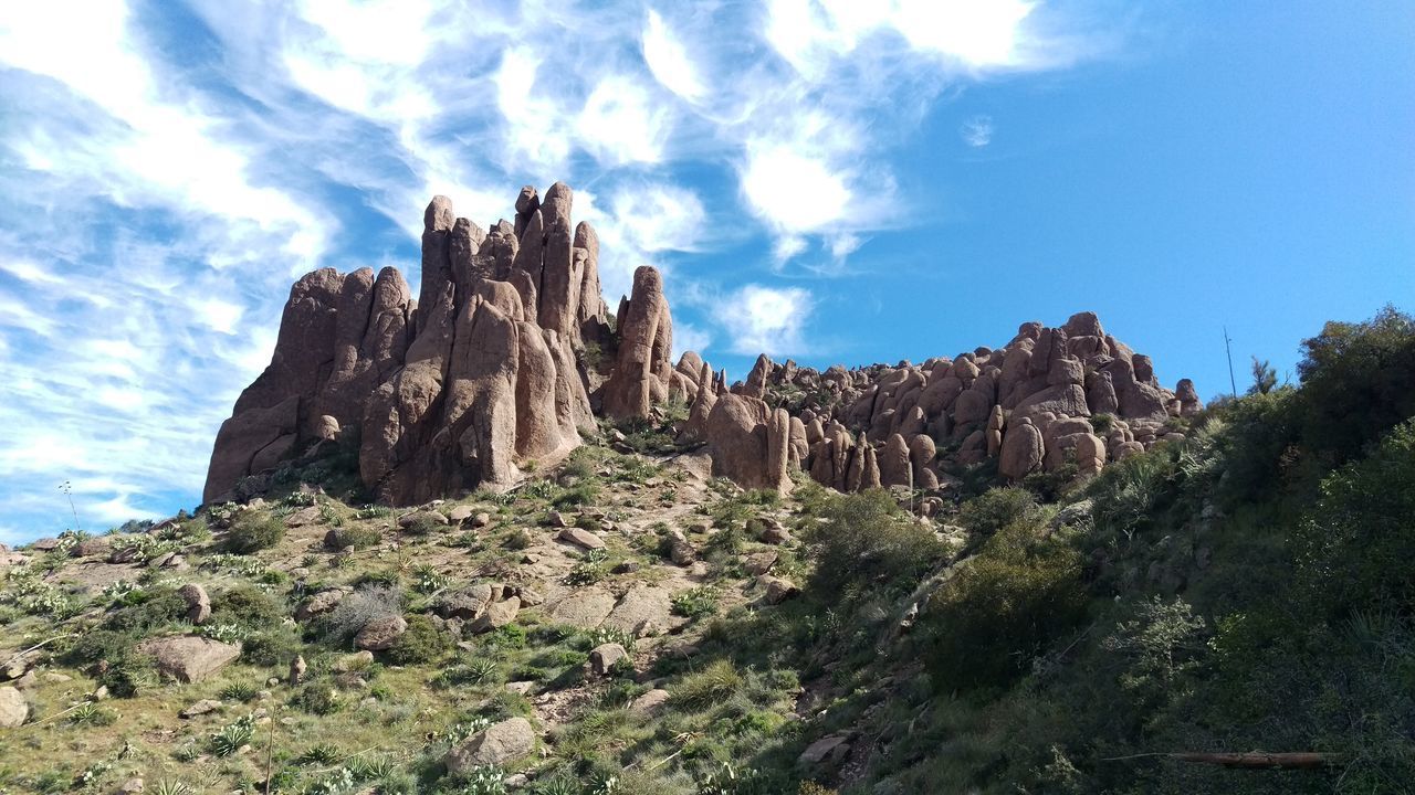 LOW ANGLE VIEW OF ROCKS ON MOUNTAIN AGAINST SKY