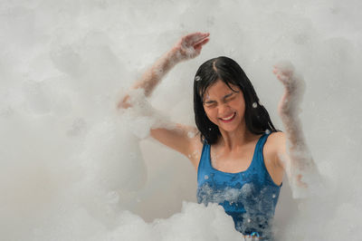 Young woman smiling while standing in water