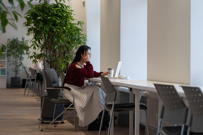 Young asian woman working remotely in modern public library, japanese female student studying online