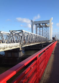 Bridge over river against sky in city