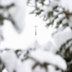 Low angle view of cross tower against sky during winter