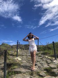 Full length of woman standing on land against sky