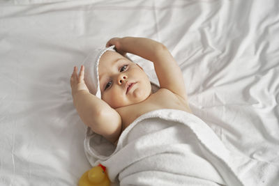 Portrait of cute baby lying on bed