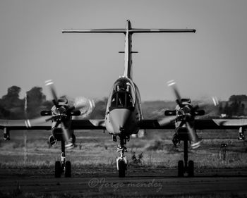 Airplane on airport runway against sky