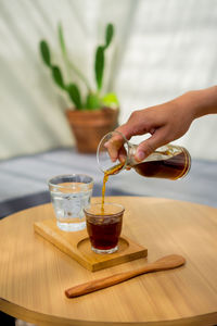 Midsection of man holding drink on table