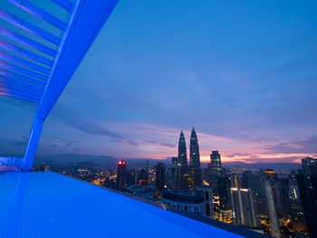 View of city lit up against blue sky