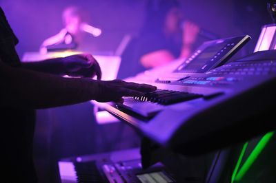 Musician playing piano on stage during concert