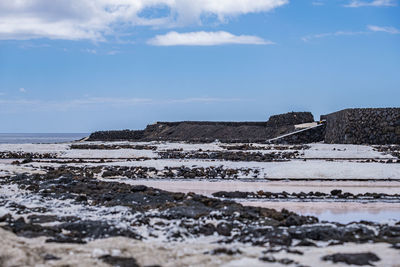 Surface level of salt pan against sky