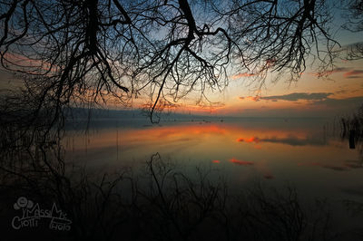 Scenic view of lake against sky at sunset