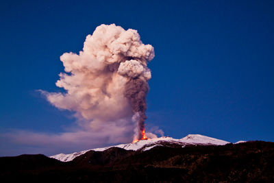 Smoke emitting from volcanic mountain against sky