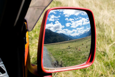 View of landscape through side-view mirror