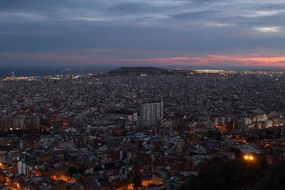 Illuminated cityscape against sky during sunset