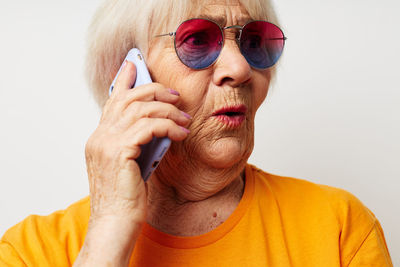 Senior woman talking on phone against white background