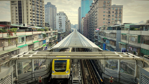 Train with buildings in the city. 