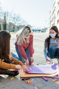 Female friends doing work during protest